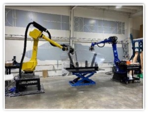 A picture of robotic arms on factory floor.